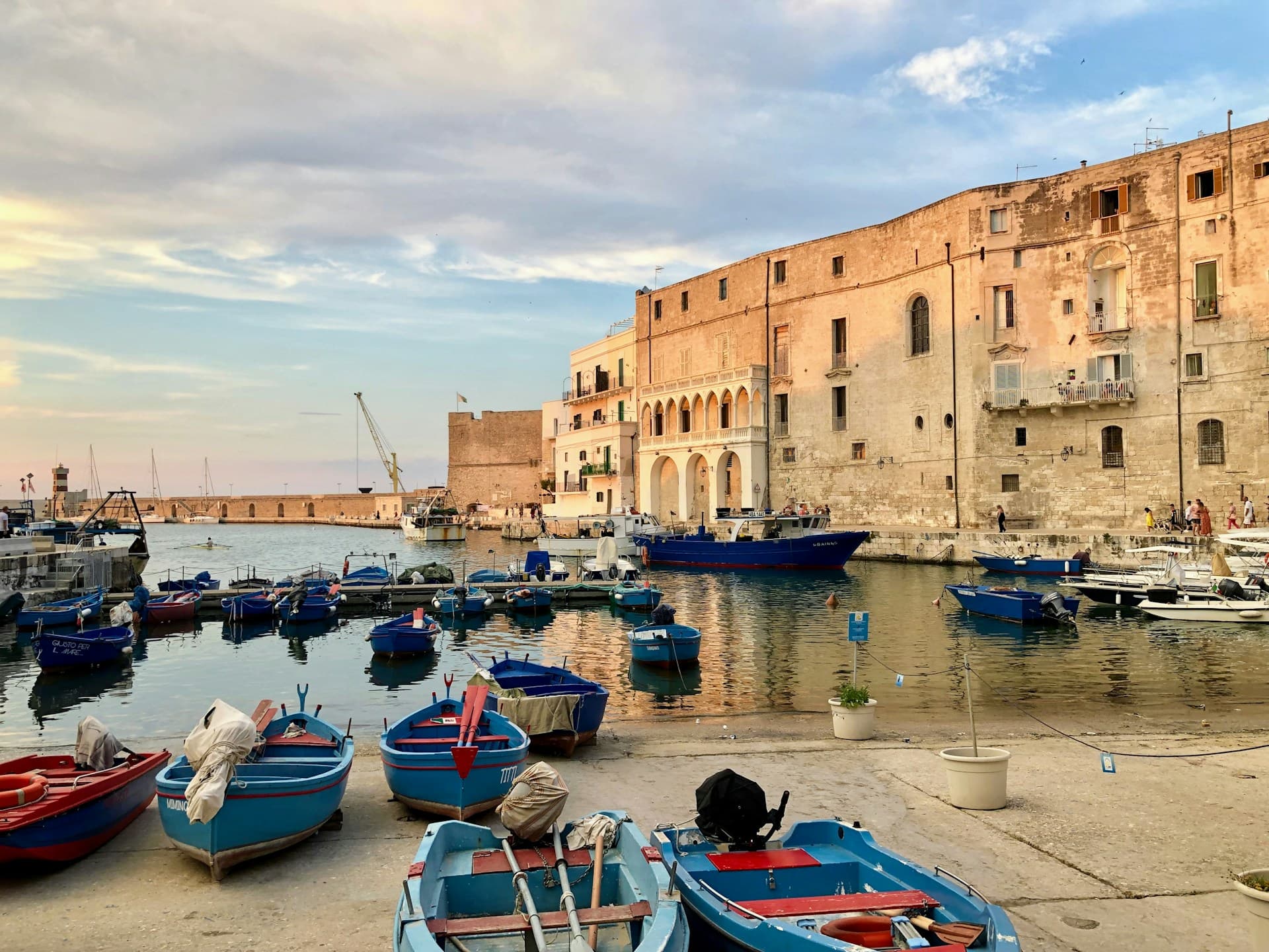 Harbour in Monopoli City with blue boats and small view of historic centre